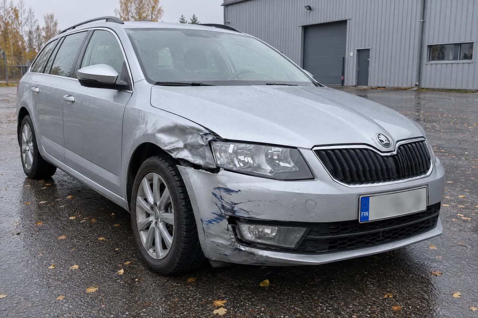 Parkkipaikkakolarissa kolhiintunut farmariauto: lokasuoja painunut ja puskurin kulma naarmuuntunut